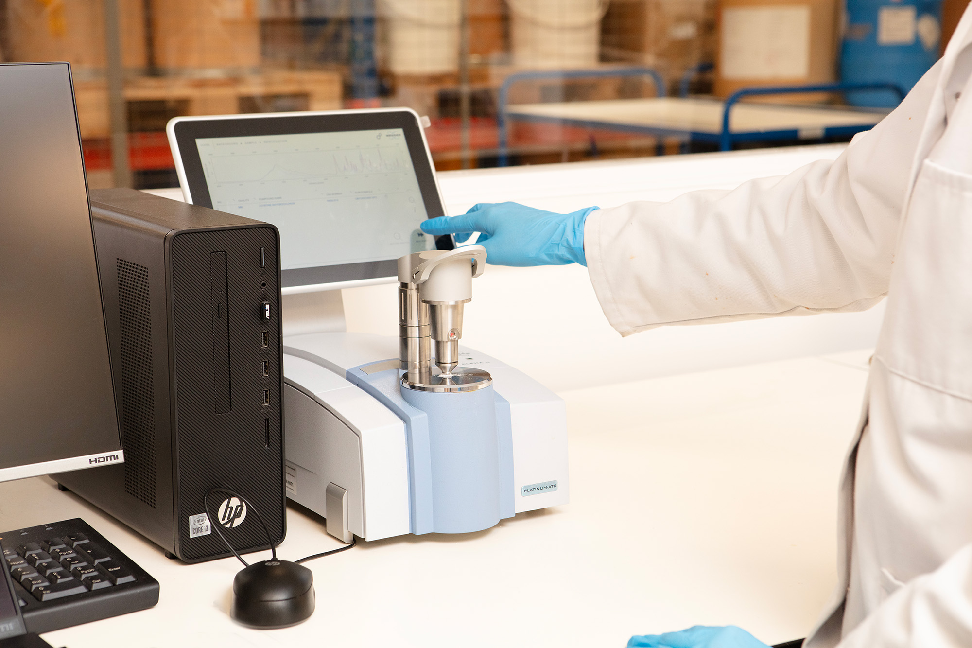 Photo showing a scientist squirting a light pale blue liquid from a syringe into a plastic chemical storage block.